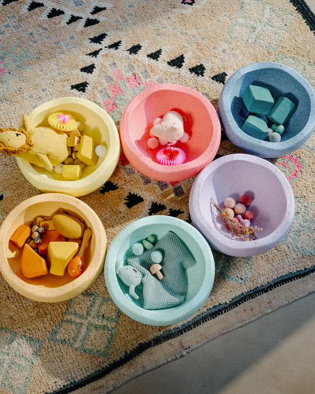 Set of colorful stepping stones with small items on a patterned surface